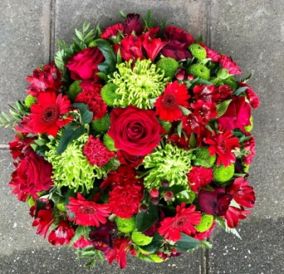 Funeral flat posy in red and green - Sympathy flowers are a beautiful way to let someone know that you are thinking of them at a sad time.

This flat posy pad tribute includes red roses and gerberas set with green chrysanthemums.

Each tribute is designed and created by professional, qualified, local florists, Emma and her team. At this difficult time, they are here to help make choosing and ordering funeral flowers and sympathy tributes a little easier.

Almost what you're after? We can tailor your tribute to suit your needs and budget. Want to incorporate their favourite colours? All colours, styles and budgets can all be catered for.

All flowers are subject to availability. Substitutes may be used but your tribute will always look beautiful!

Order by 2pm for same day delivery. Also available to order for a day of your choice.