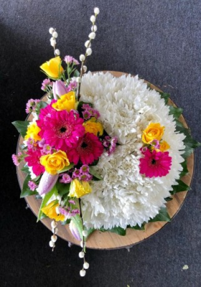 Modern posy pad - This modern posy pad consists of a double white base adorned with a vibrant spray. 

*If you would like different colours from those in the image please note this in your order notes.

Available in 4 sizes: 12" (please call to order), 14". 16" and 18".

Each arrangement is designed and created by the talented florists at Flowers of Kidderminster. Professional, qualified, local florists, Emma and her team put together each arrangement by hand, from scratch, from the wide selection of beautiful fresh flowers here in our shop on Lisle Avenue.

Each tribute is designed and expertly prepared by professional, locally based, florists Emma and Laura. At this difficult time, Emma and her team are here to help make choosing and ordering funeral flowers and sympathy tributes a little easier.

All arrangements are created from our collection of fresh flowers at our shop in Lisle Avenue, Kidderminster.

Almost what you're after? We tailor all funeral tributes to your specific requirements. We can incorporate their favourite colours or create a style that reflects their personality. Come in and talk to us about what you would like and we will create it for you.

All flowers are subject to availability. Substitutes may be used but your tribute will always look beautiful!

Funeral Tributes can be delivered on the day to a location of your choice.